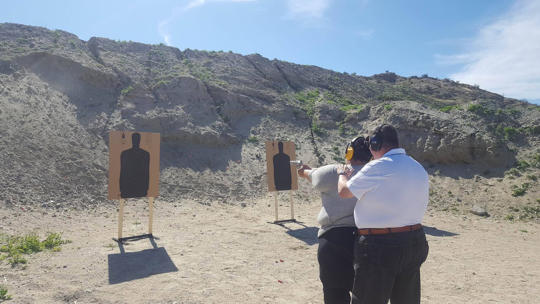 Instructor assisting student at firing range