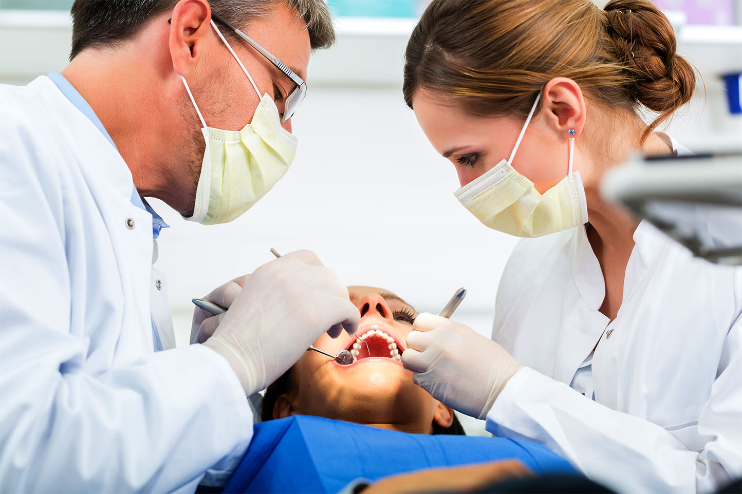 Dentist and dental assistant working on patient