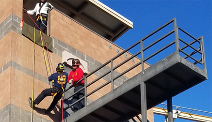 Firefighter performing low angle rope rescue