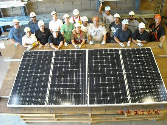 Students standing next to solar panels
